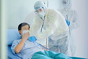 Health care staff with whole body protective suit in covid clinic protective room help to support and treatment the patient on bed