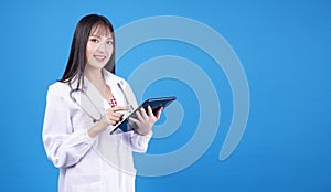 Health care technology concept. Professional pharmacist, doctor or nurse woman wear laboratory coat with stethoscope using tablet