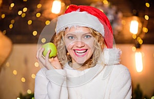 Health care. Woman Santa hat eat apple fruit christmas decorations background. Stay healthy. Diet and healthy nutrition