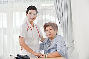 Health care worker helping an elderly patient.