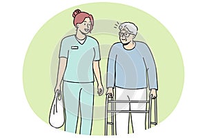 Health care worker helps elderly disabled person with walking frame.