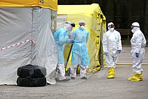 Health care workers wear protective suits as they wait for patients to be tested for coronavirus disease COVID-19 in Riga, Latvi