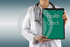 Health Check - Female doctor's hand holding medical clipboard and stethoscope on blue blurred background. Concept of Healthcare An