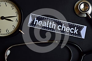 Health Check on the print paper with Healthcare Concept Inspiration. alarm clock, Black stethoscope.