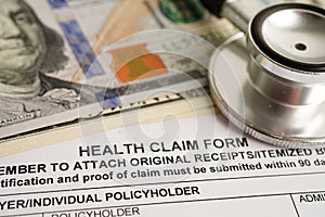 Health claim form with stethoscope and US dollar banknotes, insurance accident medical concept