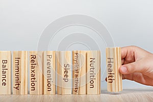 Health concept. The hand lays wooden rectangles on top of each other. Cubes with inscriptions, Physical activity