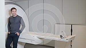 Health concept. hospital patient near MRI, tomograph, scanner, CT machine.Male smiling patient in modern healthcare