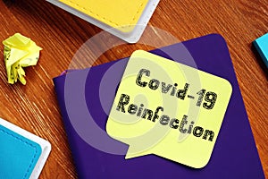 Health concept meaning covid reinfection with sign on the piece of paper photo