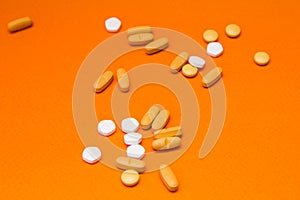 Health concept. Various pills isolated over the orange background.