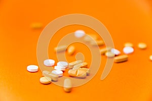 Health concept. Various pills isolated over the orange background.