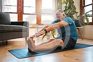 Health, exercise and yoga with senior man doing ground stretching before meditation and wellness workout. Fitness, relax