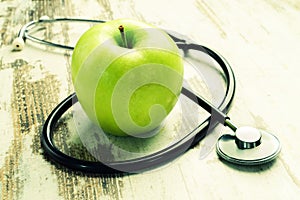 Health. Green apple with medical stethoscope