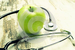 Health. Green apple with medical stethoscope