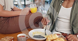 Health, hands and couple eating breakfast with fruit, coffee and juice at table for wellness diet. Food, nutrition and