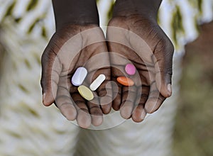 Health and Healthcare: Curing Malaria - African Girl Holding Pills Medicine Health Symbol. photo