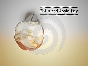 text of eat a red apple day with eaten apple background