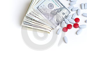 Health insurance, pharmaceutical industry concept. Pills and a wad of cash on white background.