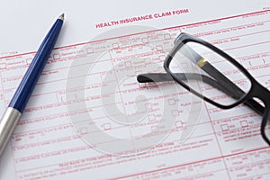 Health insurance claim form with pen and glasses