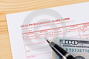 Health insurance claim form with pen on wooden desk