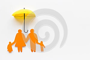 Health insurance concept. Family cutout under umbrella on white background top-down copy space