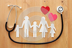Health Insurance . concept image of Stethoscope and family on wooden table.