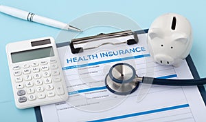 Health insurance document with calculator and piggy bank