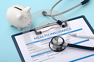 Health insurance document with piggy bank and stethoscope