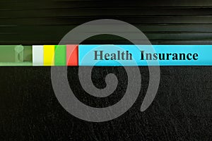 Health insurance file record in black binder folder. Health insurance benefit concept.