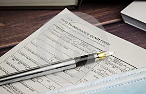 health insurance form with pen on wooden background