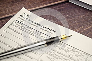 health insurance form with pen on wooden background