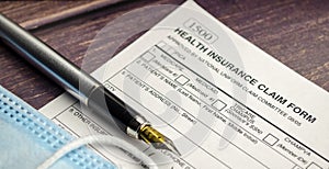 health insurance form with pen on wooden background