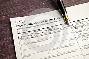 health insurance form with pen on wooden background