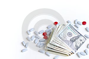 Health insurance, pharmaceutical industry concept. Red and blue pills on white background next to a wad of cash.