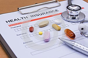 Health insurance paperwork, medicine, stethoscope. Health insurance claim concept.
