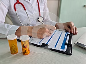 Health insurance payment form and pills on medical table