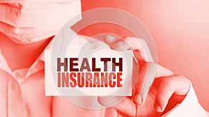 Health insurance words on the card in hands of Medical Doctor. Healthcare concept