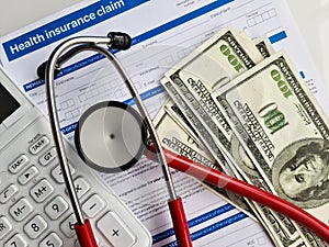 Health and medical insurance claim form with stethoscope on clipboard money dollars
