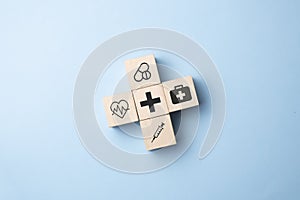 Health medical Insurance Concept, wood cube with medical symbol on pastel blue background, copy space