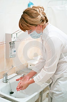 Health occupation worker washing her hands