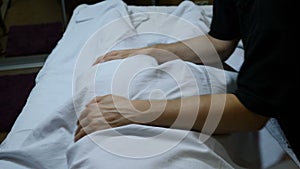 Health and overweight concept. masseur`s hands make remedial massage through towel. massage to adult fat woman`s body in