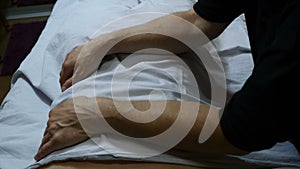 Health and overweight concept. masseur`s hands make remedial massage through towel. massage to adult fat woman`s body in