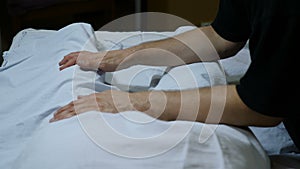 Health and overweight concept. masseur`s hands make remedial massage through towel. massage to adult fat woman`s legs in