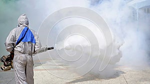 health personal worker using fogging machine spraying chemical to eliminate mosquitoes and prevent dengue fever