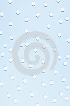 Health and pharmacy remedies for prevent and therapy disease and illness background - white pills pattern on pastel blue color.