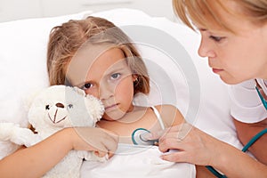Health professional checking sick little girl