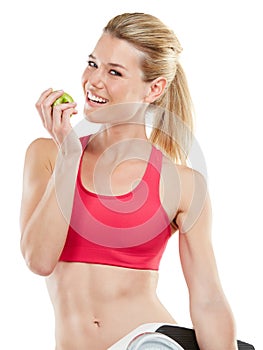 Health is a relationship between you and your body. Studio shot of an athletic young woman eating an apple.