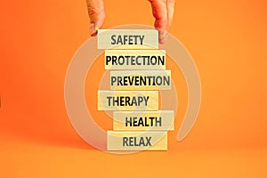 Health and safety symbol. Concept words Safety Protection Prevention Therapy Health Relax on wooden blocks on a beautiful orange