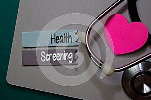 Health Screening write on stick note isolated on Office Desk. Healthcare concept photo