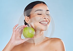 Health, skincare and beauty woman with an apple for wellness, healthy and organic lifestyle in studio. Girl with clear