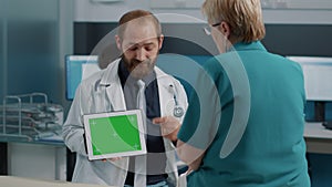 Health specialist showing tablet with horizontal green screen